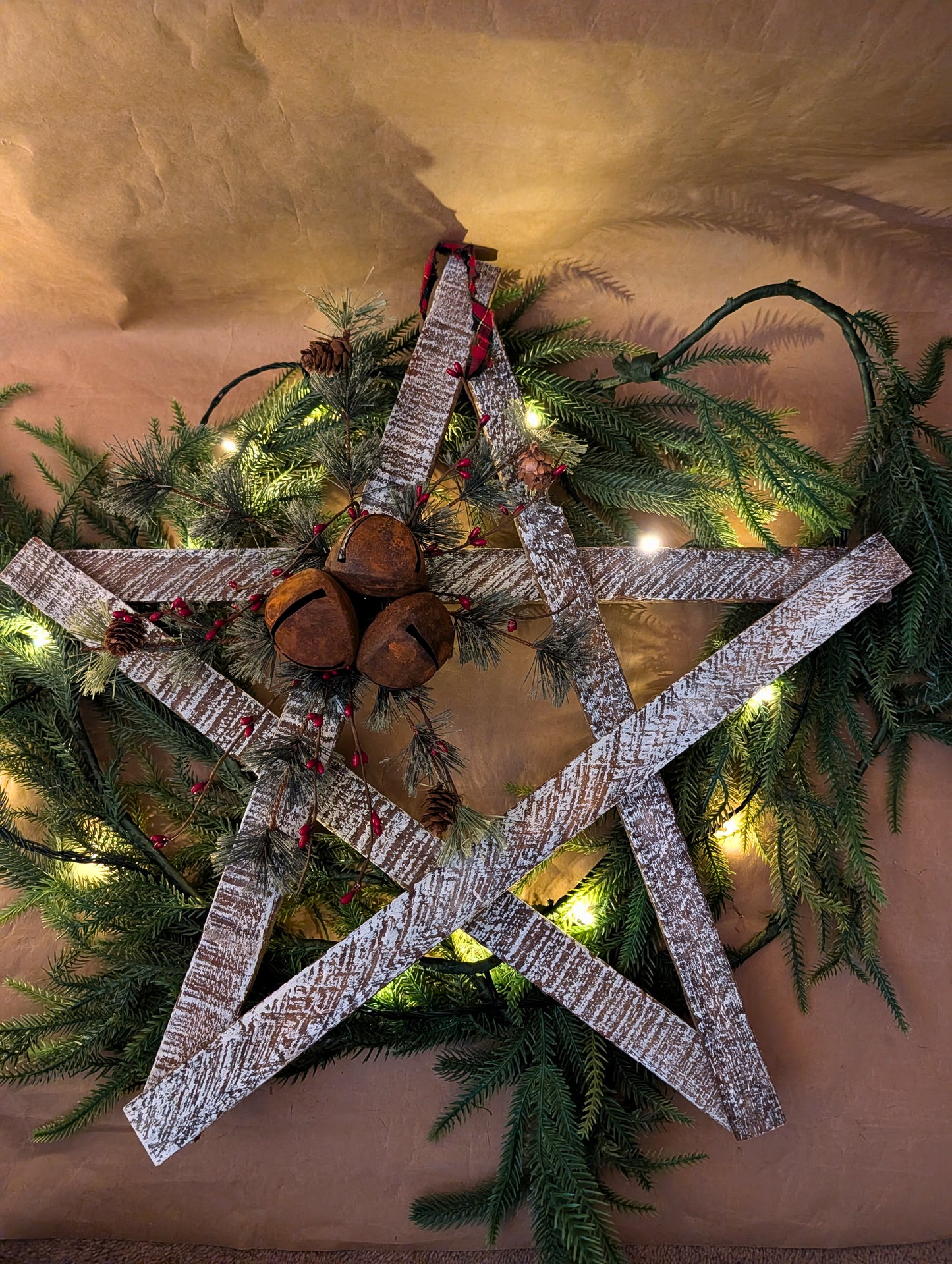 Decorative star with wooden elements and pinecones on a Christmas wreath.