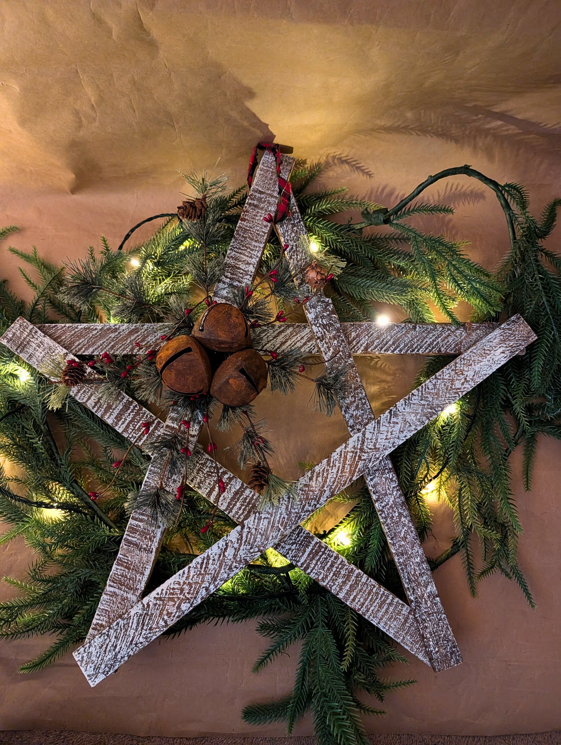 Decorative star with wooden elements and pinecones on a Christmas wreath.