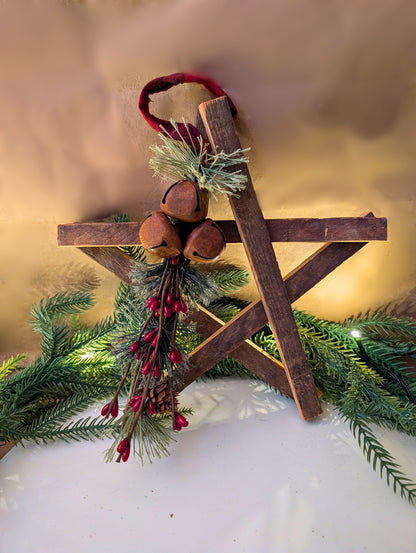 Decorative wooden cross with greenery and red berries on a textured surface