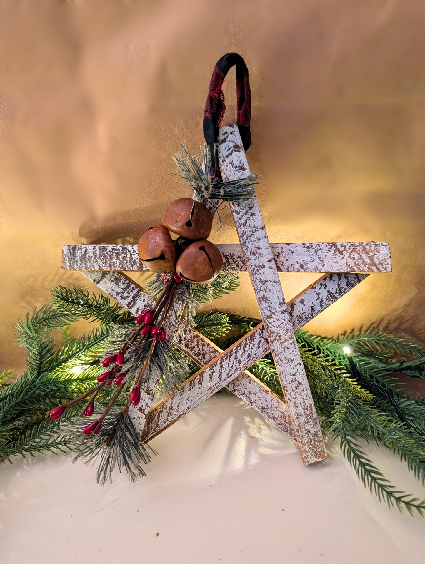Decorative star with greenery and bells on a gold background