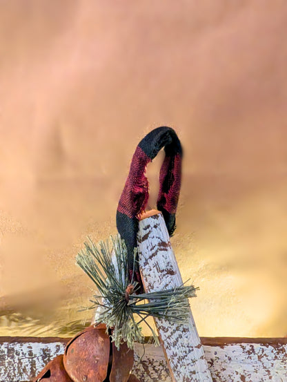 Decorative element with a black and red ribbon tied around a branch against a warm-toned background